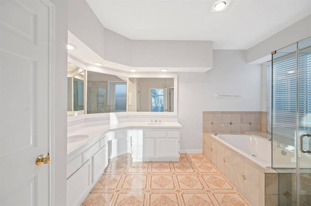 This master bathroom is definitely move-in ready! Featuring a walk-in shower, separate garden tub and light color cabinets with separate vanities.