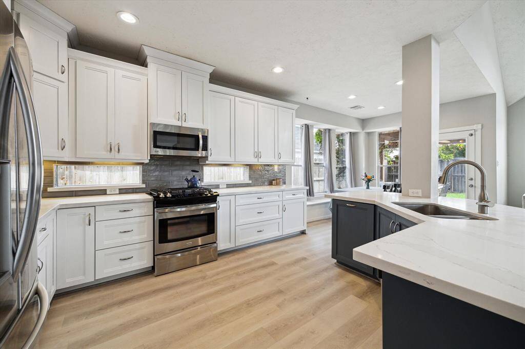 Expansive kitchen with sleek stainless steel appliances.