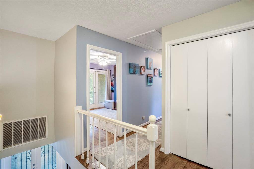 The landing at the top of the stairs.  More storage behind the folding doors.