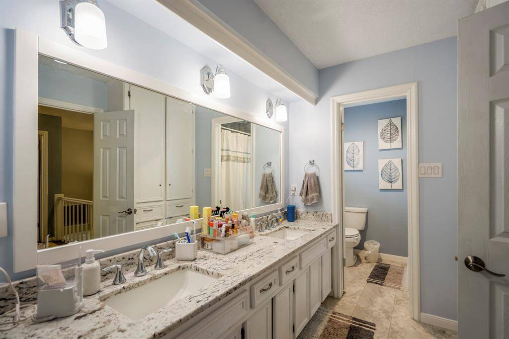 This bathroom has also been renovated with grantite, and updated tile flooring and fixtures.  Two sinks and built in laundry hampers and cabinets as well.