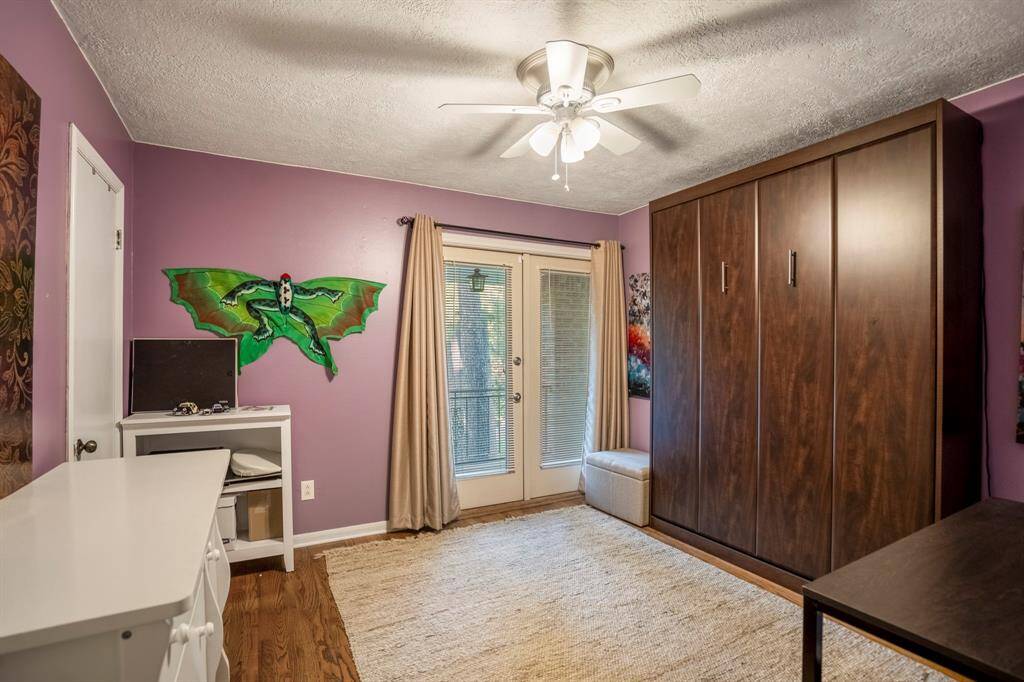 This bedroom has wood flooring, double doors to the balcony, and a Murphy bed which will stay with the home.  The mattress won't stay.