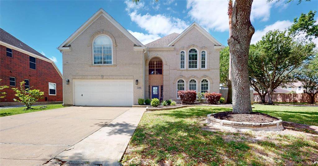 This two-story brick home features a spacious front yard with mature trees and landscaping. Large arched windows provide plenty of natural light. Ideal for blend of comfort and style.