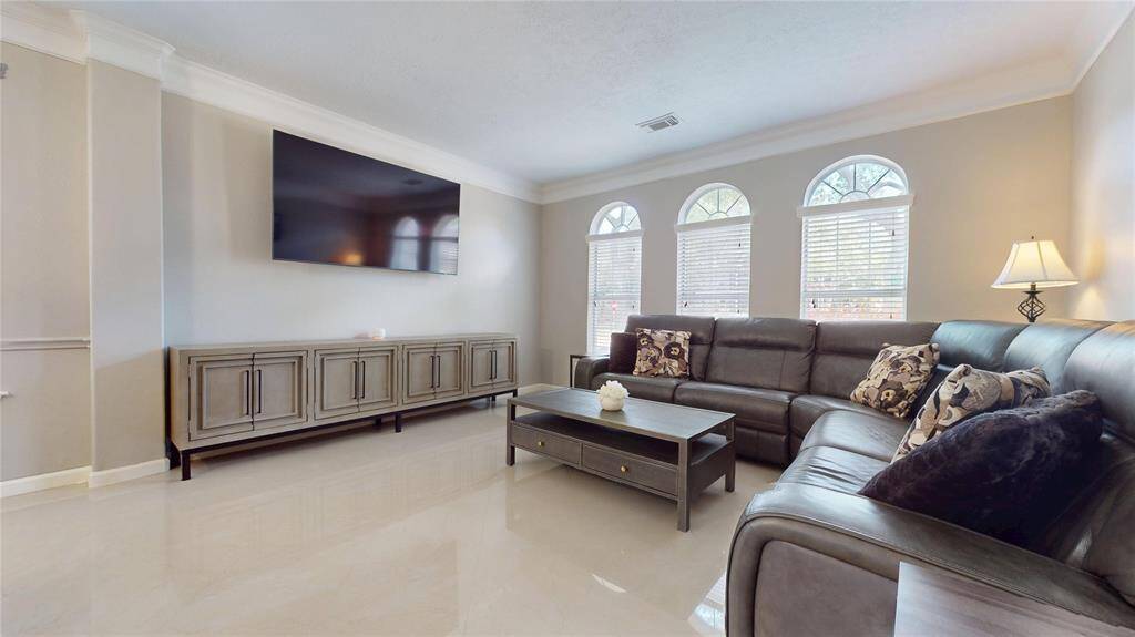 This spacious formal living room features ample natural light from three arched windows.
