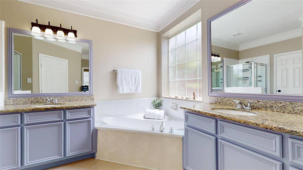 Primary Bathroom with separate counters and sinks, large vanity mirrors and soaking tub.