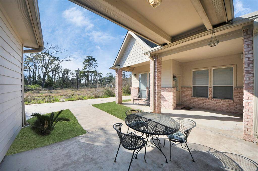 At the back of the home, a generous covered patio overlooks the expansive yard
