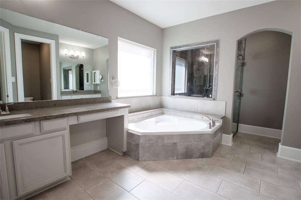 Large primary bathroom with two vanities, soaking tub, two walk in closets and large custom handicap accessible shower