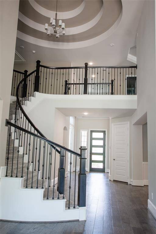 Curved staircase and accented ceiling make for a welcoming yet dramatic entrance