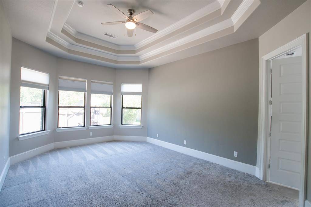 Large primary bedroom full of natural light