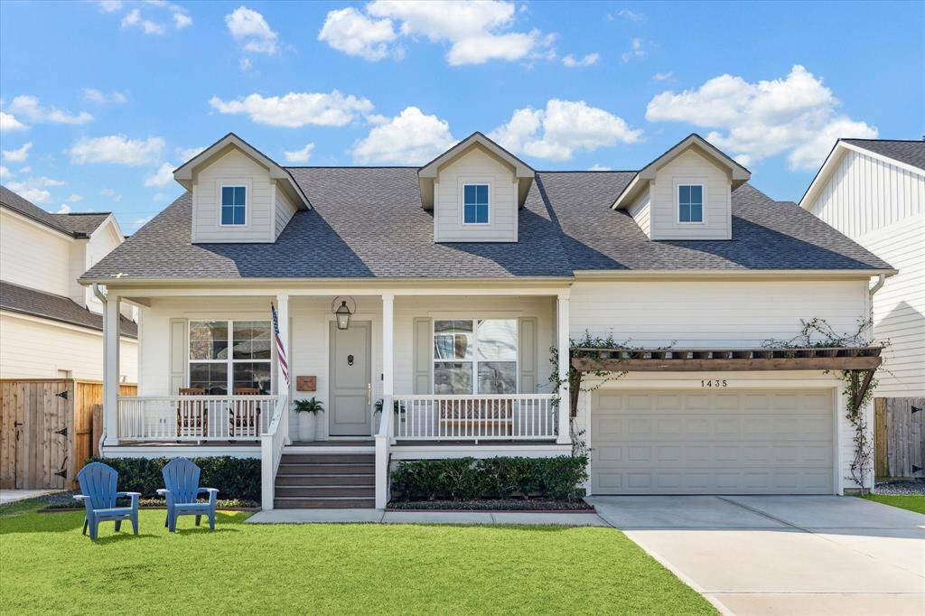 Framed by a charming front porch and detailed dormer windows, this inviting home blends classic curb appeal with thoughtful updates. Climbing greenery accents the pergola above the garage, while crisp white siding and a welcoming entry set a relaxed tone. Situated on a manicured lot, it offers a picture-perfect first impression.