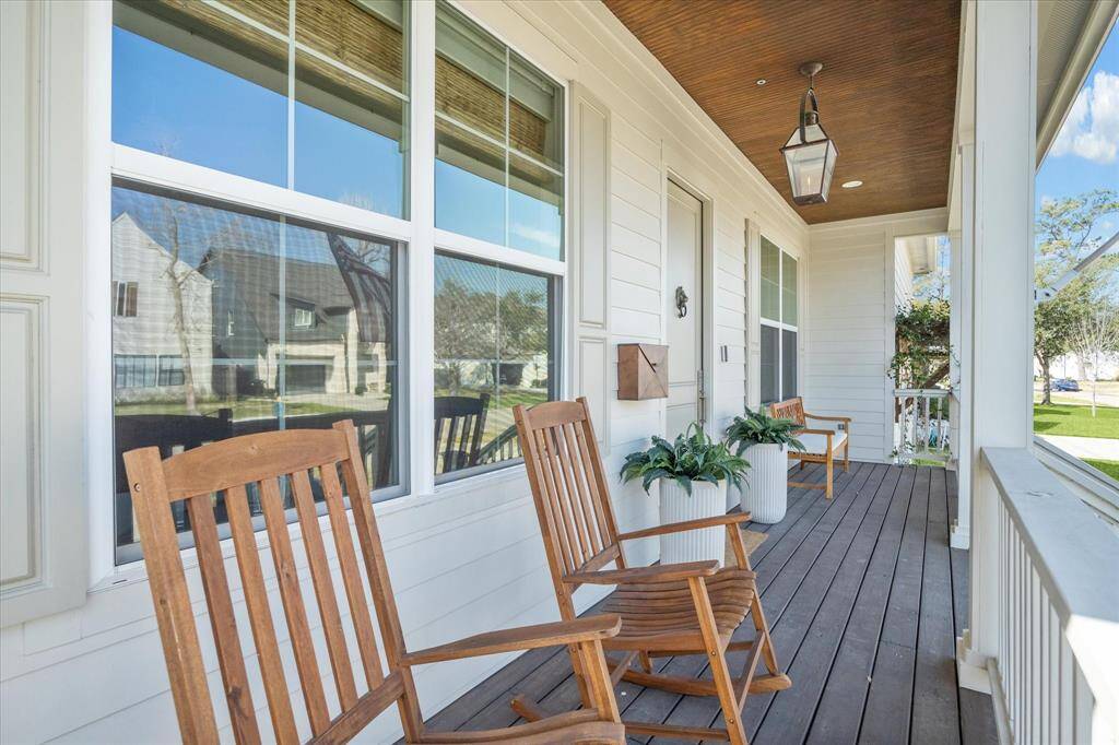 Wood accents and a lantern-style fixture add charm to this front porch, offering the perfect spot to relax with a morning coffee or evening drink. Surrounded by fresh landscaping and shaded by a classic overhang, it’s a welcoming extension of the home’s Southern-inspired curb appeal.