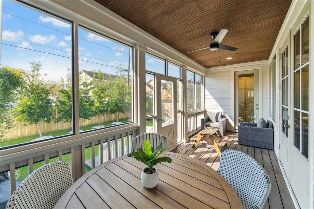 The screened-in back porch provides a peaceful, bug-free retreat with views of the backyard and surrounding greenery. A wood-paneled ceiling with recessed lighting and a ceiling fan adds warmth and comfort, making this an ideal spot for dining, relaxing, or entertaining year-round.