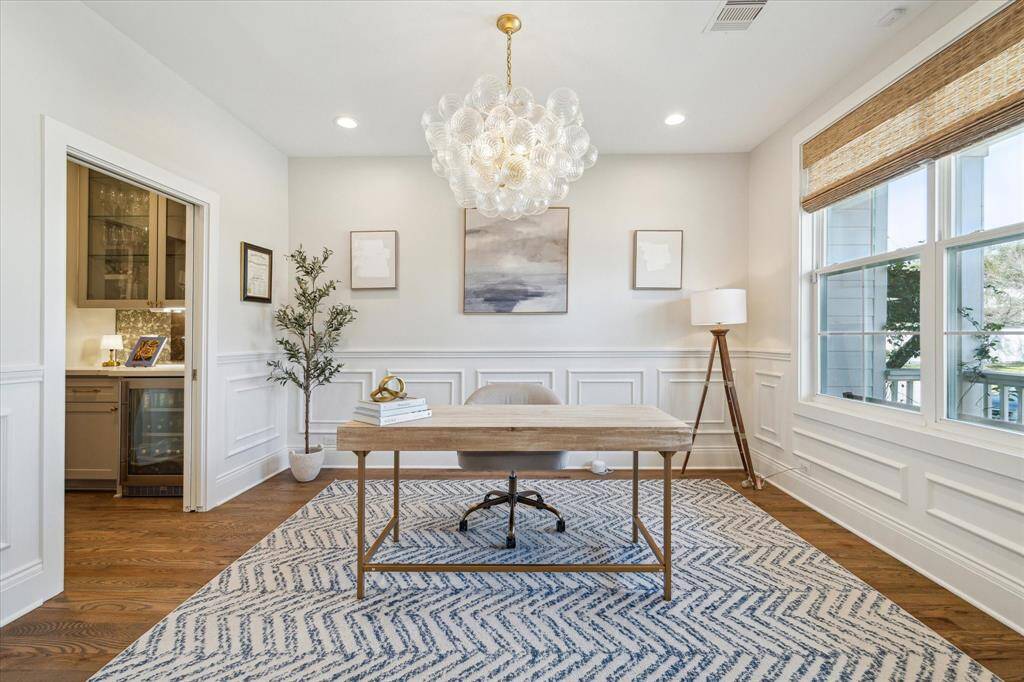 Detailed millwork, abundant natural light, and a statement chandelier elevate this front-facing study into a sophisticated work-from-home retreat. A built-in wet bar just off the room adds convenience and style, ideal for hosting or taking a break between meetings.
