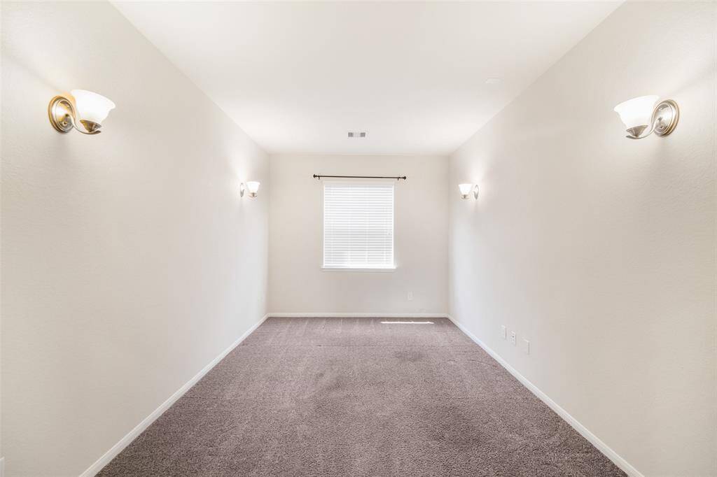 The media room is located just off the family room and features carpet flooring, wall-mounted lighting, and a window.