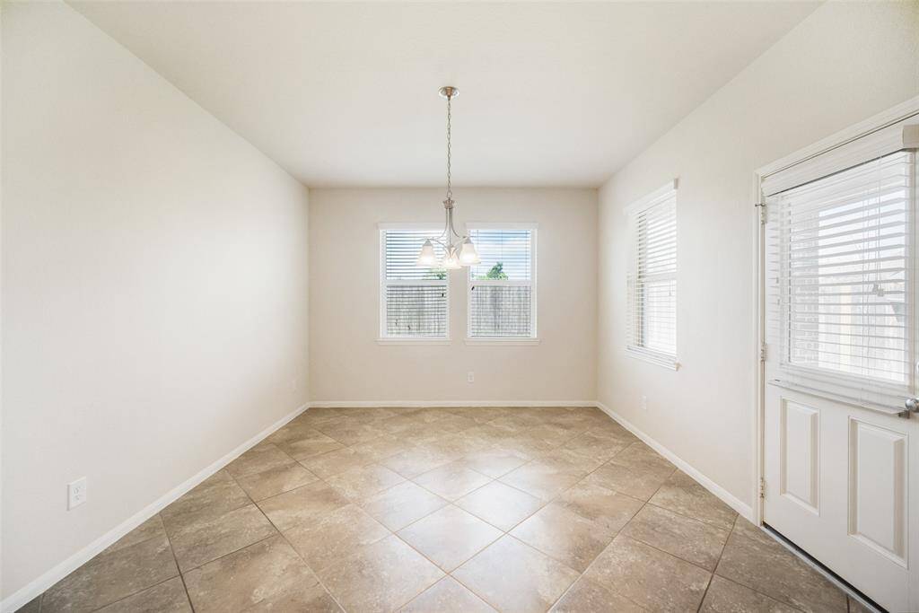 The cozy breakfast room, located just off the kitchen, offers views of the backyard and fills with natural light from the surrounding windows.