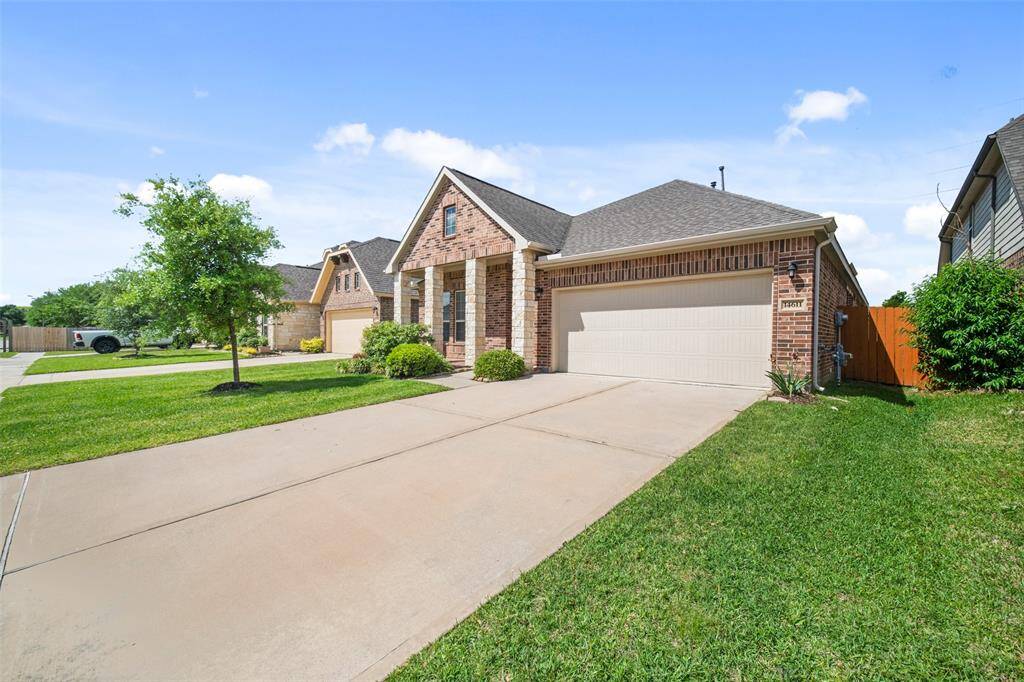 An alternate side view of the home showcasing the attached two-car garage and driveway.