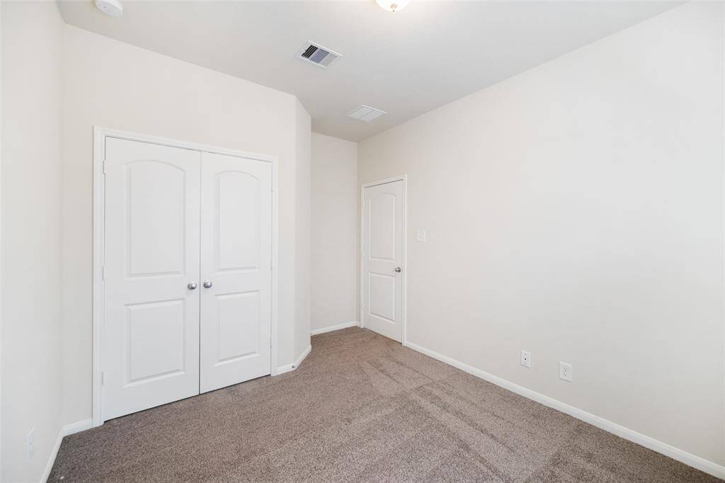 This bedroom features a double-door closet, cozy carpet flooring, and a window that fills the space with natural light.