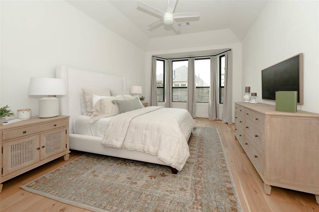 Bright primary bedroom featuring an elegant bay window.