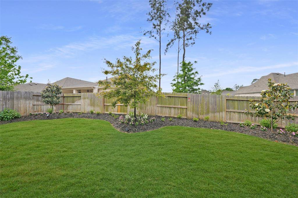 Lush maple trees enhance the serene beauty of this backyard oasis.
