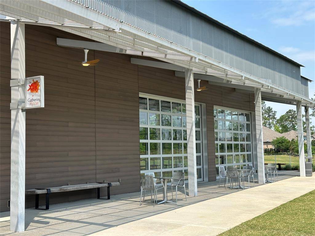 Discover a modern fitness center featuring expansive glass doors and a welcoming outdoor seating area, perfect for relaxation and community gatherings.