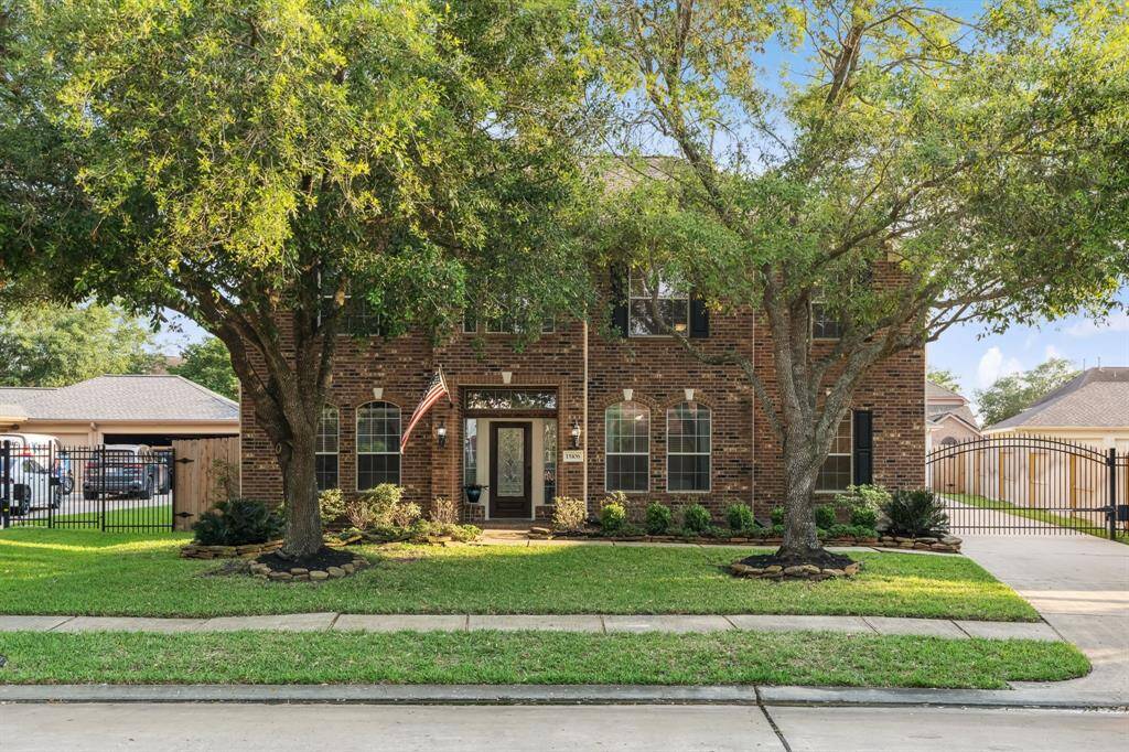 This charming two-story brick home features a well-maintained front yard with mature trees, a gated driveway, and attractive landscaping. The large windows provide ample natural light, and the inviting entrance adds to its curb appeal.