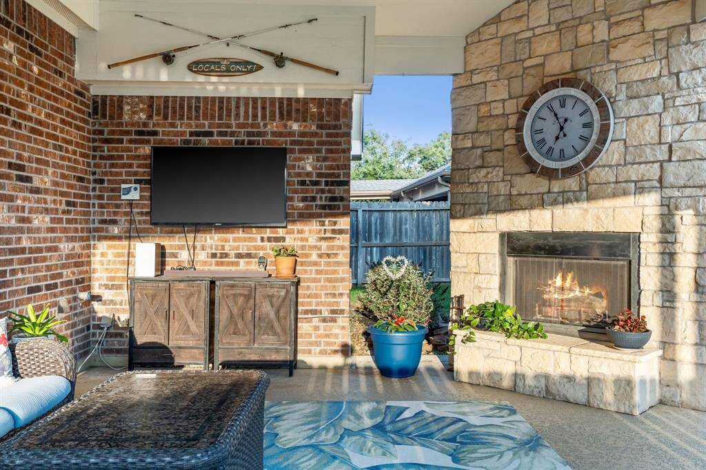 Outside gas log fireplace with stone surround and raised hearth.