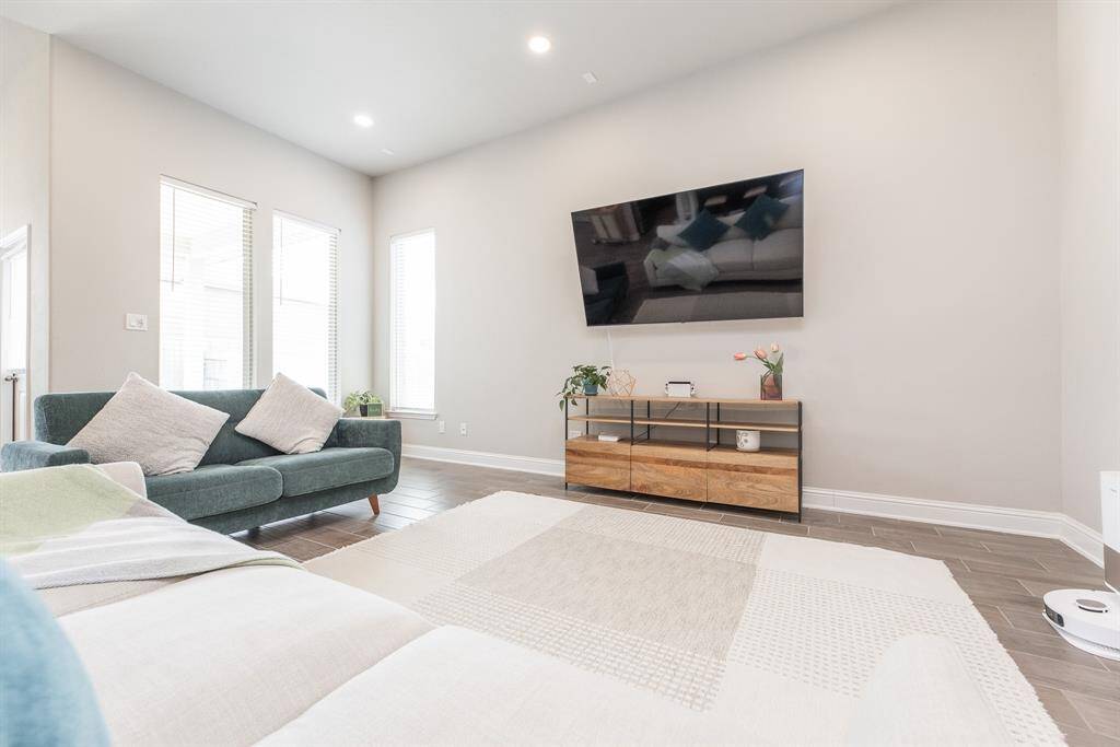 This spacious living room features mount for a TV and windows offering abundant natural light.