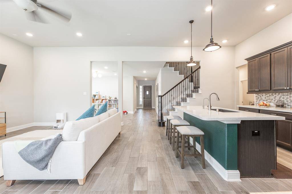 The open layout includes a large island and elegant pendant lighting