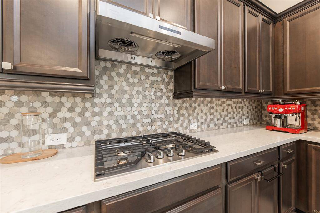 This modern kitchen features granite countertops, built in burner and wall oven