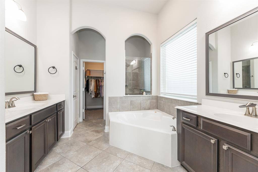 Primary bathroom features his and her vanities.