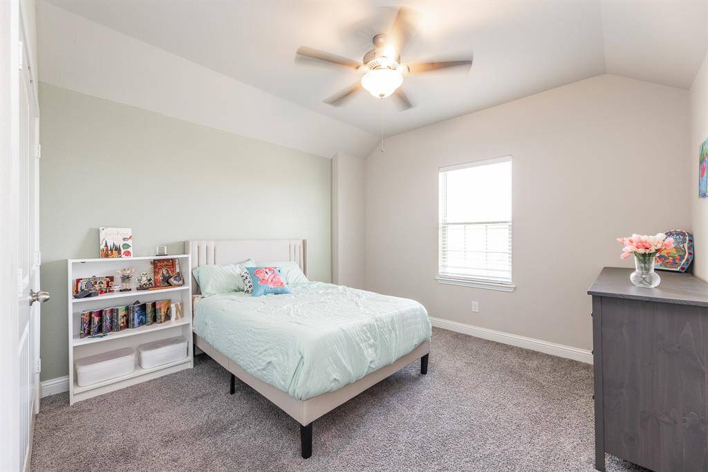 This 2nd bedroom upstairs features neutral walls, a ceiling fan, a window for natural light.