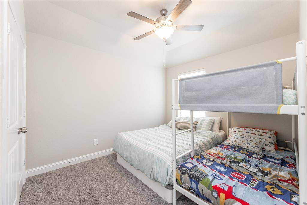 This 3rd bedroom upstairs features neutral walls, a ceiling fan, a window for natural light.