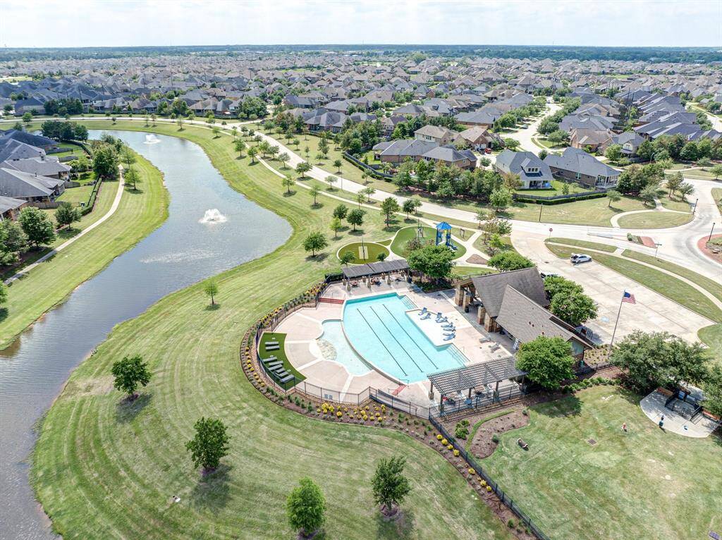 This photo shows vibrant community park with a playground and the pool