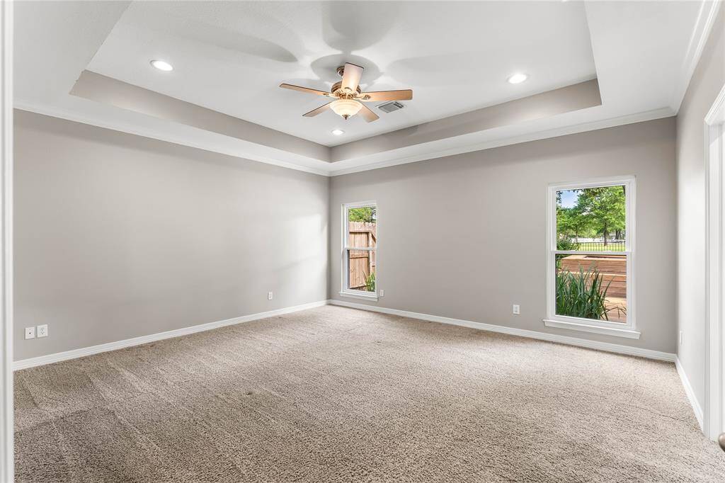 Oversized primary bedroom down with trayed ceiling and tons of room!