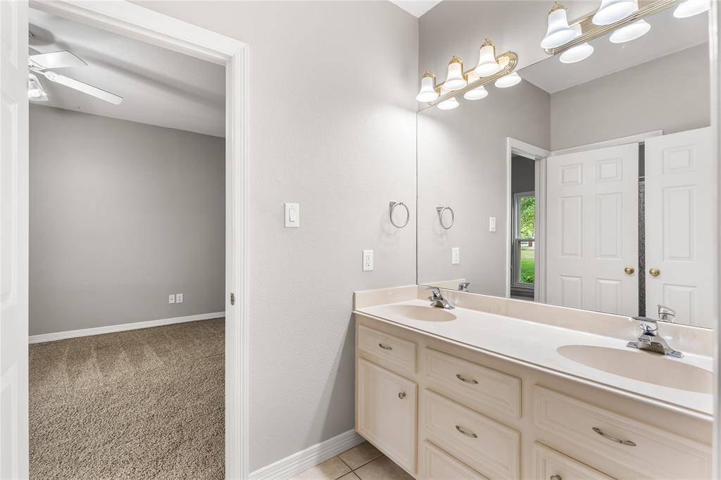 Views of Jack & Jill bath shared between two secondary bedrooms with dual sinks.