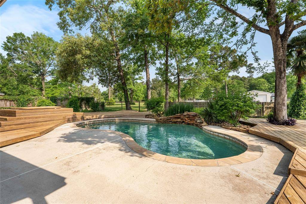 Pool with waterfall and views of hot tub.