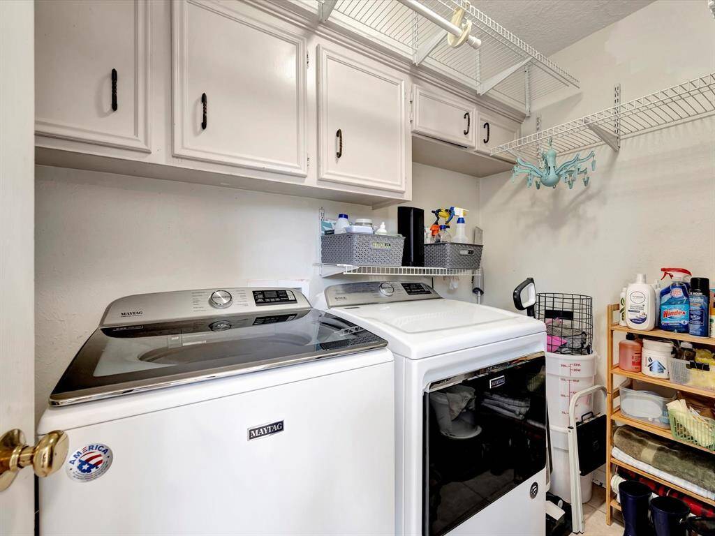 Laundry room with cabinets and shelving.