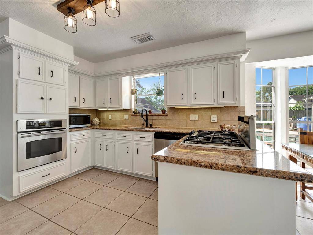 Granite counters and 5-burner gas cooktop.