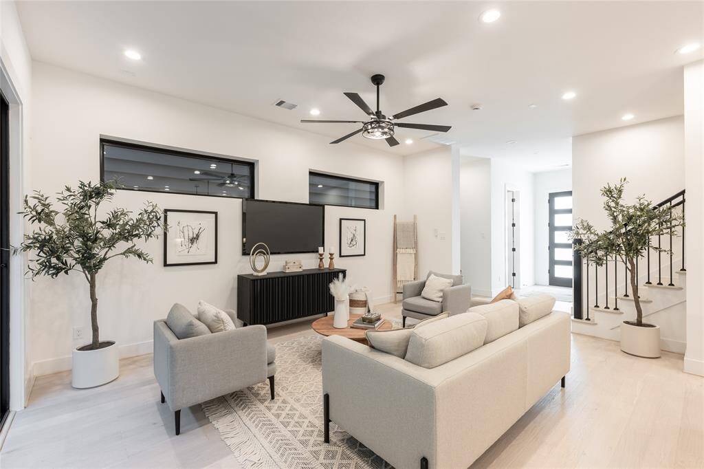 Thoughtfully placed recessed lighting and oversized windows add depth and dimension to this refined living environment.