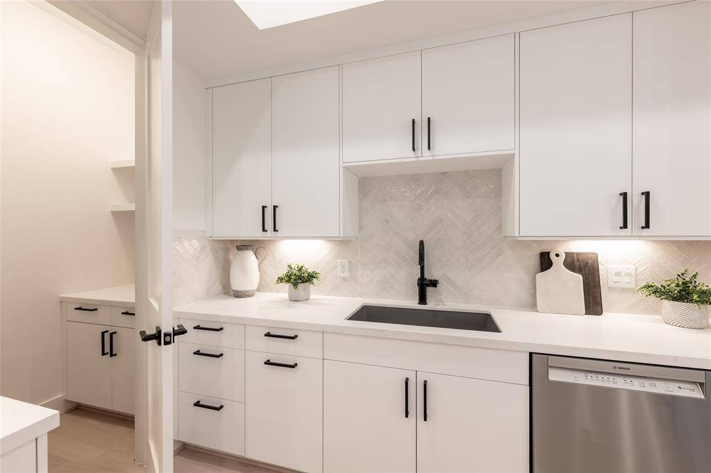 A sophisticated blend of warm wood tones and crisp white cabinetry creates a timeless aesthetic.