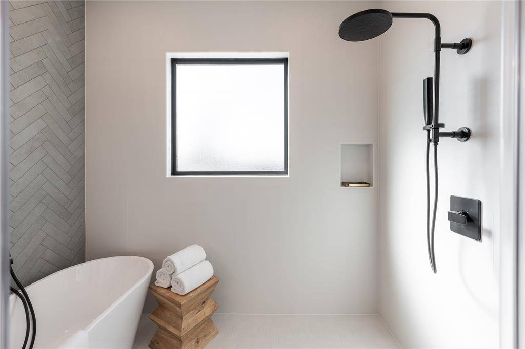 The seamless blend of stone, glass, and wood tones makes for a tranquil yet visually captivating space.