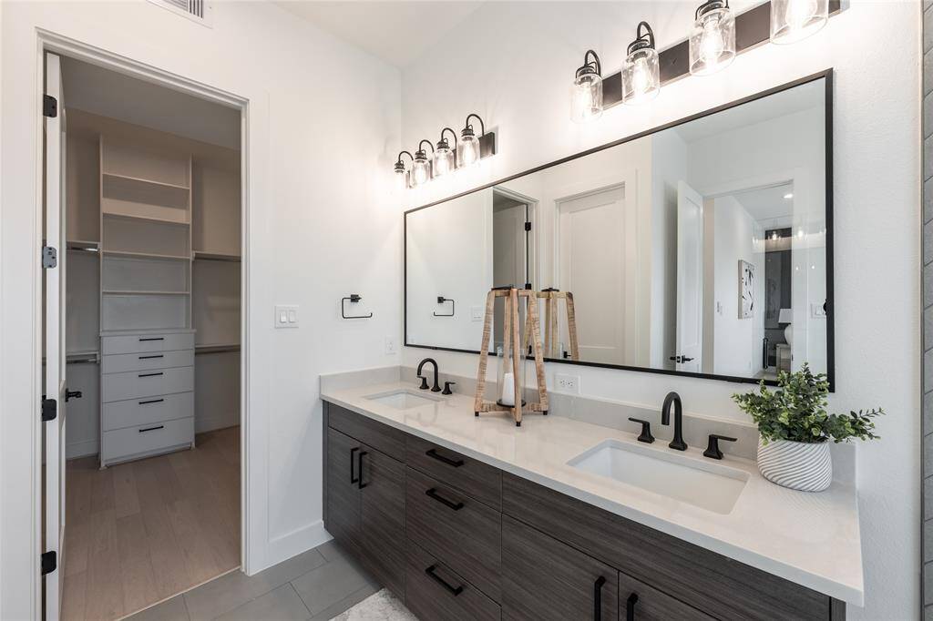 The dual vanity sinks with sleek fixtures and custom cabinetry enhance both functionality and style.