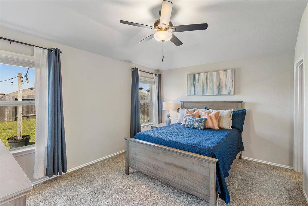 Unwind in this spacious primary suite featuring soft natural light and a relaxing color palette.
