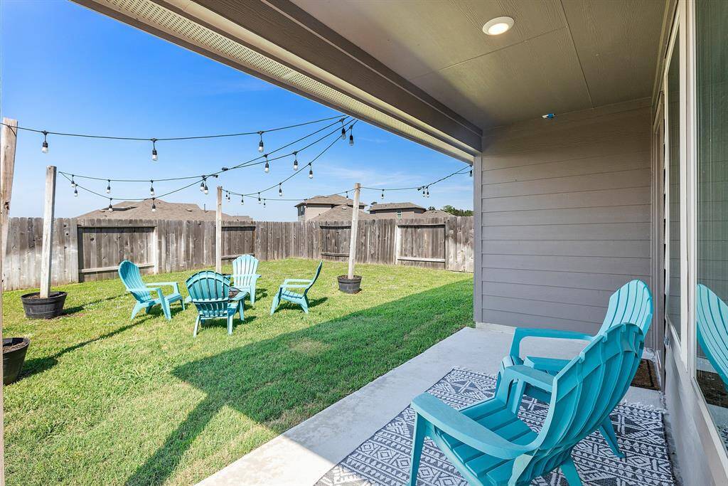 Relax in style under this spacious covered patio, perfect for unwinding or hosting under the warm glow of string lights.