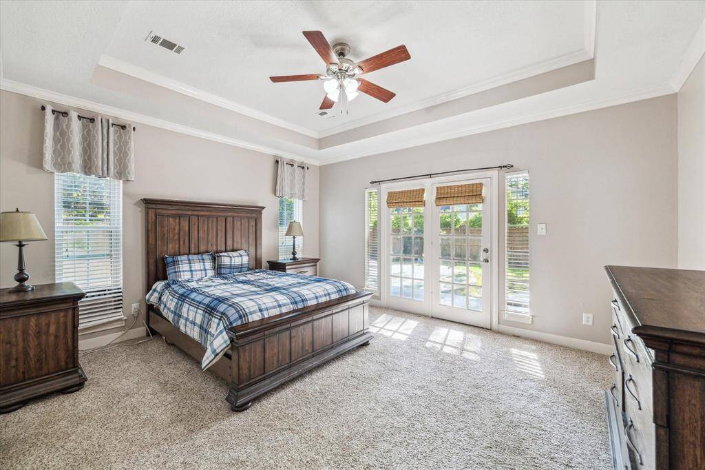 Primary bedroom with french door that lead to the putting green and covered patio