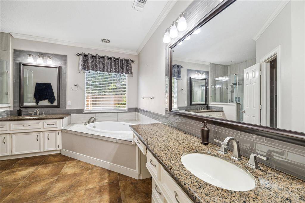Primary ensuite bath with soaking tub and seperate vanities