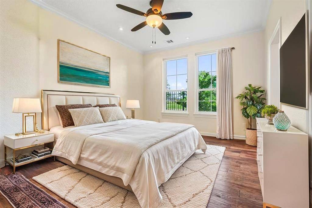 FIRST FLOOR BEDROOM FEATURES RICH HARDWOOD FLOORING AND LARGE WINDOWS THAT FLOOD THE SPACE WITH NATURAL LIGHT. **This room has been virtually staged.