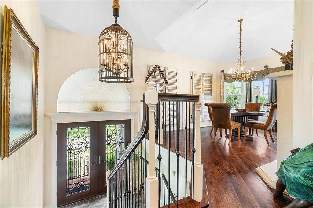 SOARING TWO-STORY CEILING CREATES A GRAND ENTRYWAY, ACCENTUATED BY AN ELEGANT, CAGED CHANDELIER.