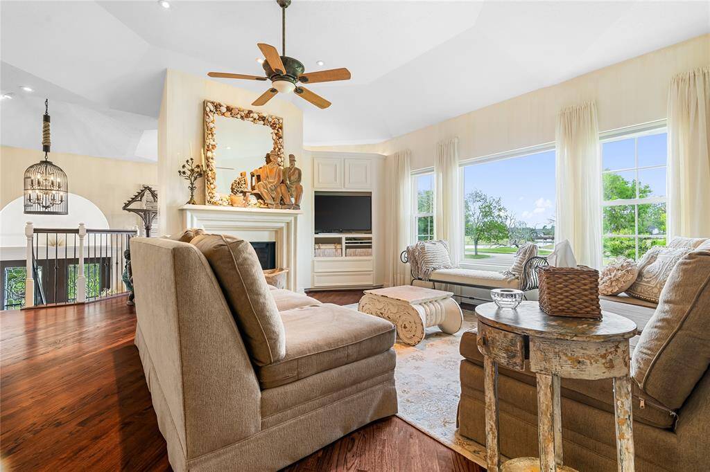 THE MAIN LIVING ROOM FEATURES VAULTED CEILINGS, WALL-TO-WALL WINDOWS, AND A BUILT-IN ENTERTAINMENT CENTER—ALL CENTERED AROUND A DOUBLE-SIDED FIREPLACE.