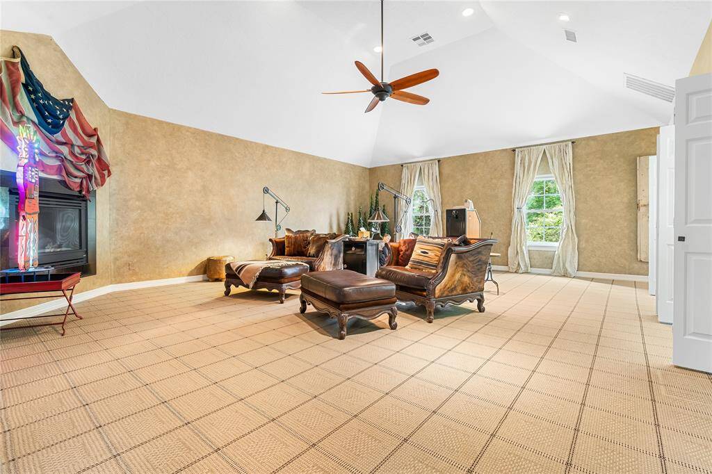 SOARING VAULTED CEILINGS AND NATURAL LIGHT FROM DOUBLE WINDOWS CREATE AN AIRY, INVITING ATMOSPHERE IN THIS SPACIOUS GAME ROOM.