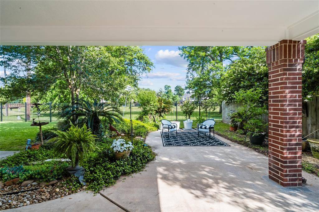 RELAX UNDER THE SHADED COVERED PATIO OVERLOOKING A WELL-MANICURED YARD AND A SEATING AREA THAT OPENS TO GOLF COURSE VIEWS.